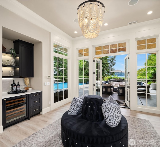 4207 Holly Ln, Mercer Island, WA 98040 - interior space with wine cooler, a bar, french doors, light wood-type flooring, and crown molding