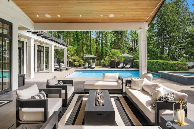 4207 Holly Ln, Mercer Island, WA 98040 - view of swimming pool featuring outdoor lounge area, an in-ground hot tub, a patio area, and view of wooded area