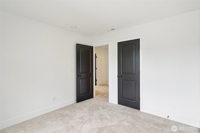 unfurnished room featuring light colored carpet and baseboards