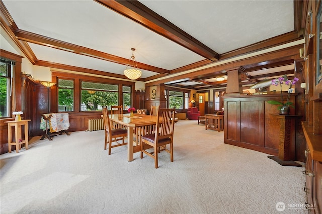 dining space featuring carpet floors, beam ceiling, radiator, and a decorative wall