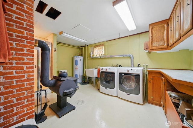 laundry room featuring water heater, washer and dryer, and cabinet space