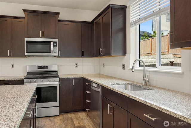 3303 103rd Dr NE, Lake Stevens, WA 98258 - kitchen with stainless steel appliances, decorative backsplash, dark brown cabinets, and light stone countertops