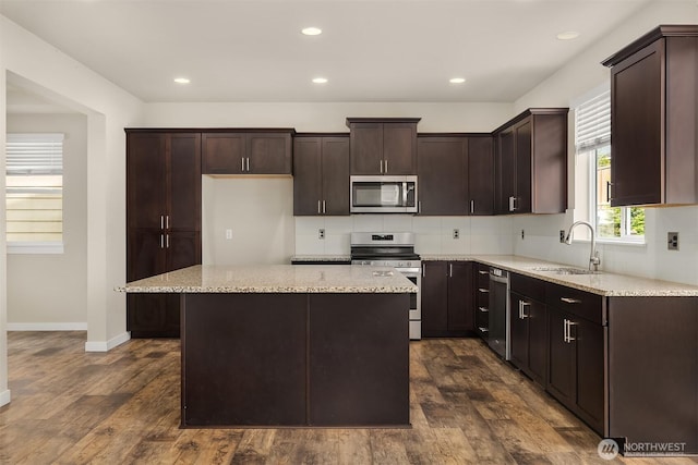 3303 103rd Dr NE, Lake Stevens, WA 98258 - kitchen with appliances with stainless steel finishes, dark wood-type flooring, dark brown cabinets, tasteful backsplash, and a kitchen island