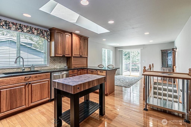 2117 130th Dr NE, Lake Stevens, WA 98258 - kitchen with a skylight, a sink, dark countertops, light wood-style flooring, and recessed lighting