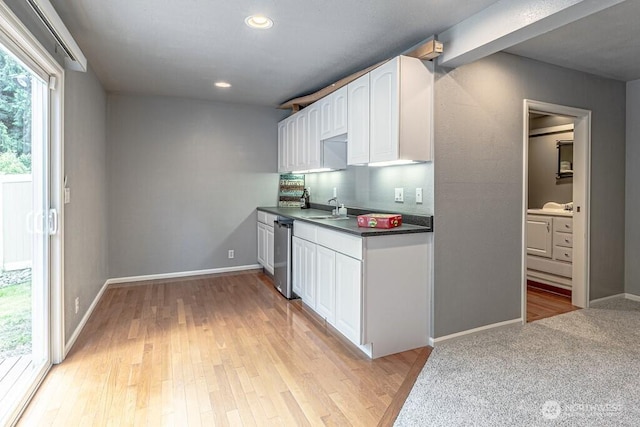 2117 130th Dr NE, Lake Stevens, WA 98258 - kitchen featuring dark countertops, a sink, white cabinets, baseboards, and light wood finished floors