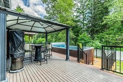 2117 130th Dr NE, Lake Stevens, WA 98258 - wooden deck with a gazebo, a hot tub, and outdoor dining space