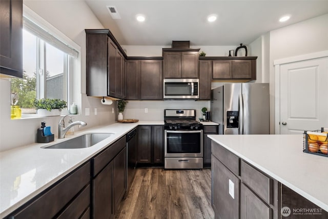 28315 64th Ct NW, Stanwood, WA 98292 - kitchen featuring stainless steel appliances, dark brown cabinetry, light countertops, dark wood-type flooring, and recessed lighting