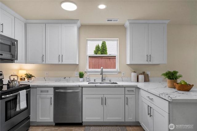 12570 SE 295th St, Auburn, WA 98092 - kitchen featuring stainless steel appliances, a sink, light stone counters, white cabinets, and recessed lighting