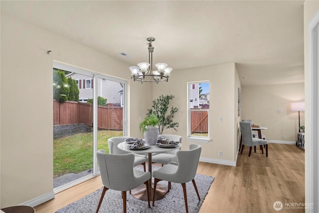12570 SE 295th St, Auburn, WA 98092 - dining room featuring light wood-style flooring, a chandelier, and baseboards