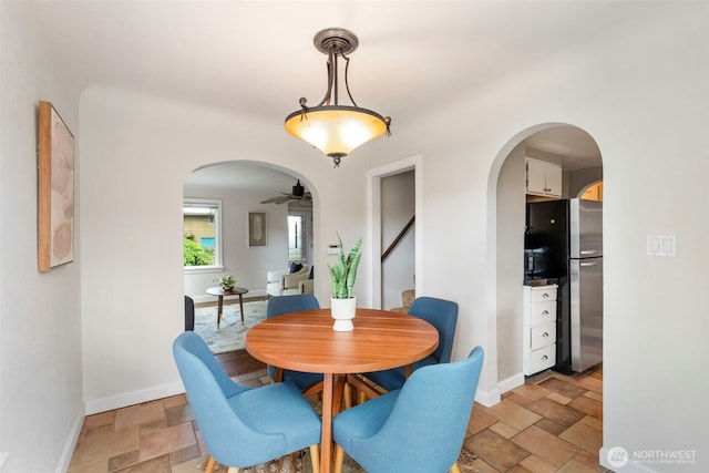 2016 Marine Dr, Bremerton, WA 98312 - dining space featuring arched walkways, stone tile flooring, baseboards, and ceiling fan