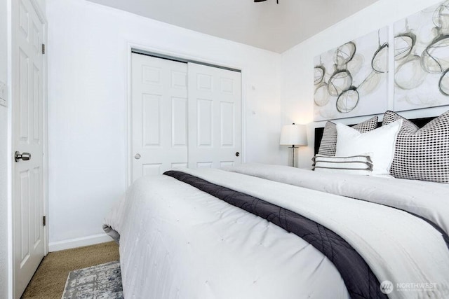 carpeted bedroom featuring baseboards and a closet