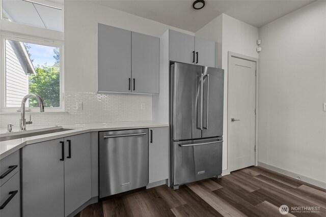 2422C NW 60th St, Seattle, WA 98107 - kitchen featuring appliances with stainless steel finishes, a sink, dark wood-style flooring, gray cabinetry, and decorative backsplash