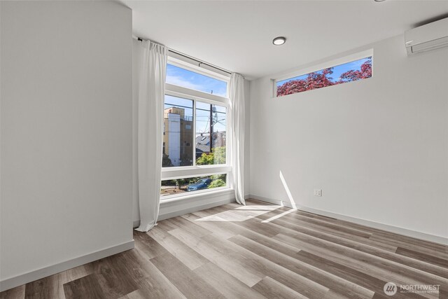 2422C NW 60th St, Seattle, WA 98107 - spare room with wood finished floors, baseboards, a wall mounted AC, and recessed lighting