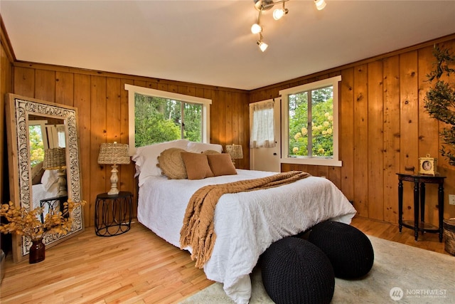 bedroom featuring wooden walls and wood finished floors
