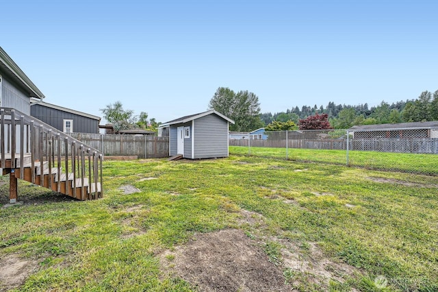 view of yard with a storage unit, an outbuilding, and stairs