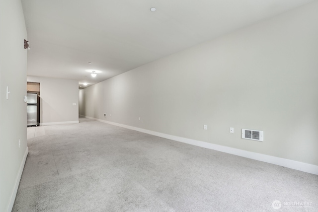carpeted empty room featuring baseboards