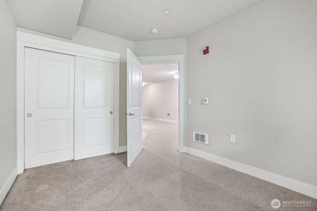 unfurnished bedroom featuring carpet floors, a closet, and baseboards