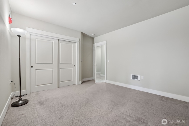 unfurnished bedroom featuring carpet, baseboards, and a closet