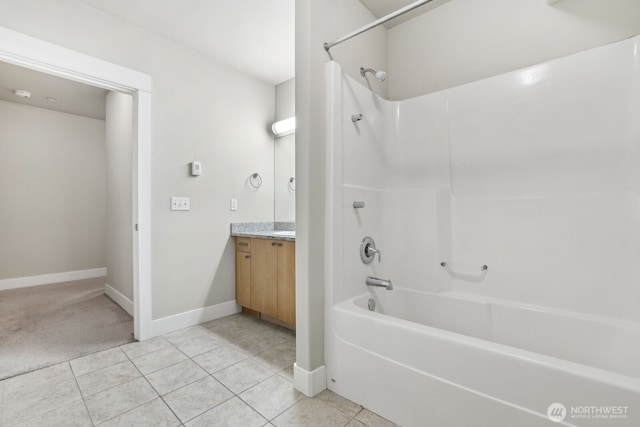 bathroom featuring bathtub / shower combination, vanity, tile patterned floors, and baseboards
