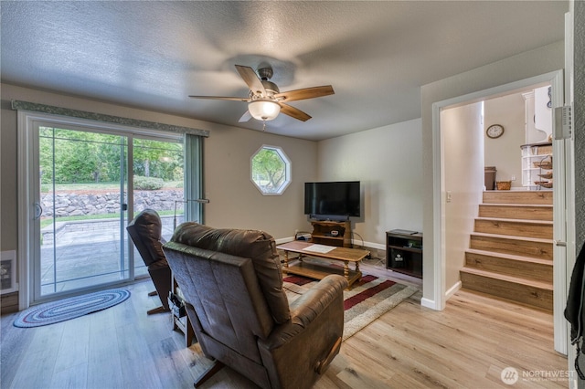 3050 NW Colonial Ln, Poulsbo, WA 98370 - living area featuring light wood-style flooring, a ceiling fan, stairway, baseboards, and a textured ceiling
