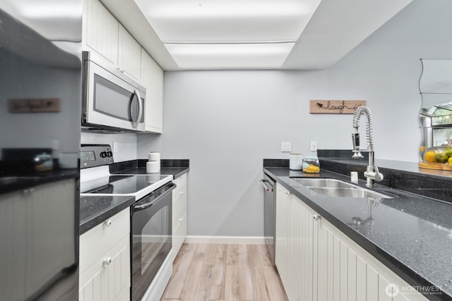 10004 NE 122nd St Unit T-D, Kirkland, WA 98034 - kitchen with appliances with stainless steel finishes, a sink, light wood-type flooring, white cabinets, and dark stone counters