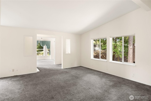 carpeted empty room featuring lofted ceiling and baseboards