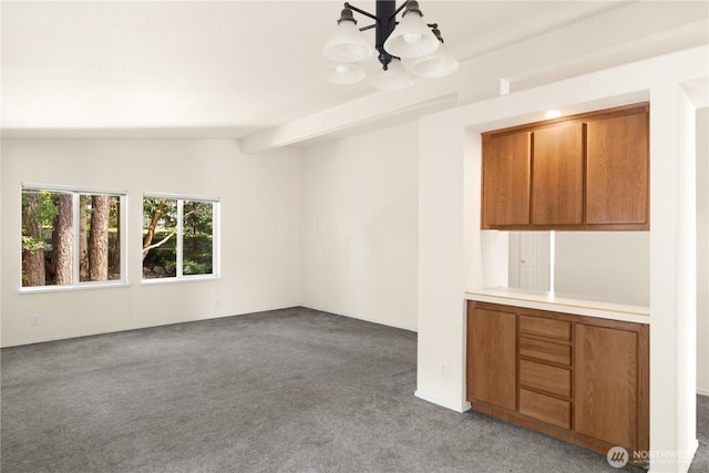 carpeted empty room featuring a chandelier