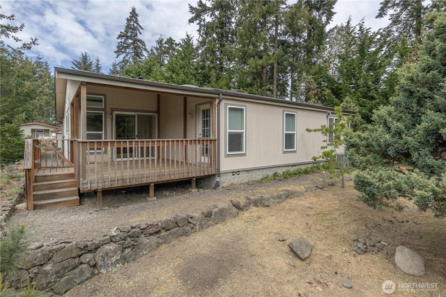manufactured / mobile home featuring a deck and view of scattered trees