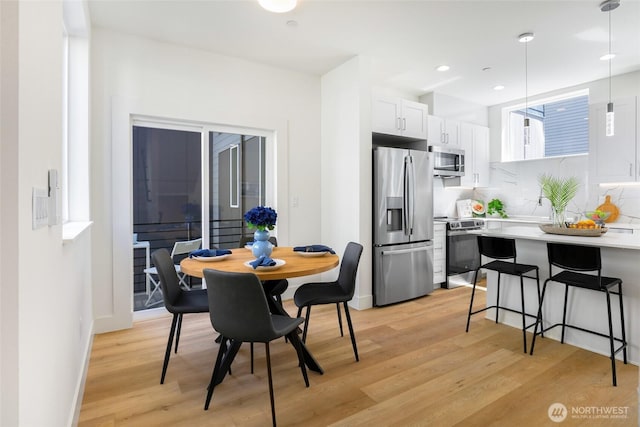 dining space featuring light wood-type flooring, baseboards, and recessed lighting