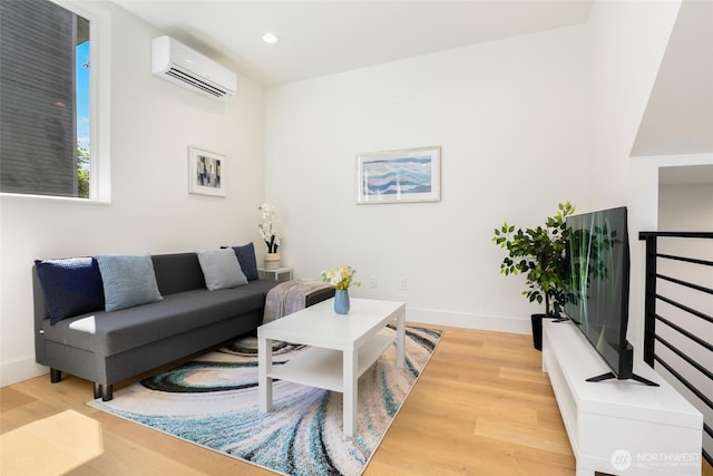 living room featuring a wall unit AC, light wood-type flooring, recessed lighting, and baseboards