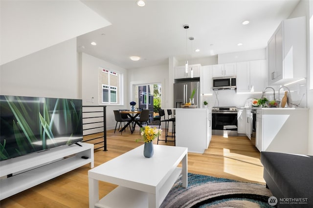 living room with light wood-type flooring and recessed lighting