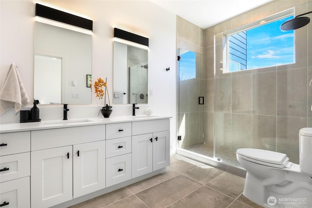 bathroom featuring toilet, tile patterned flooring, a stall shower, and double vanity