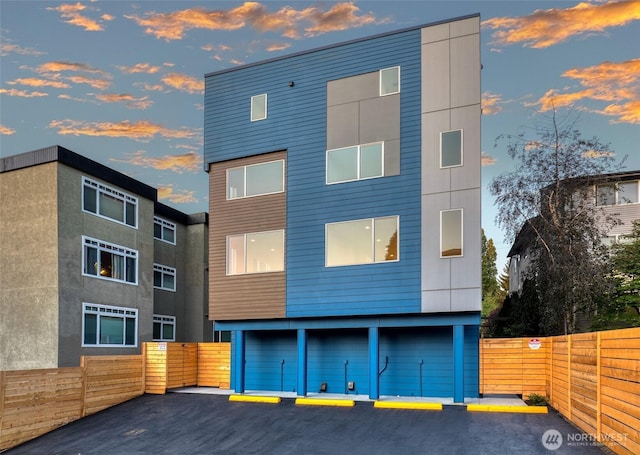 view of front of house featuring uncovered parking and fence