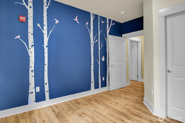 unfurnished bedroom featuring light wood-type flooring and baseboards