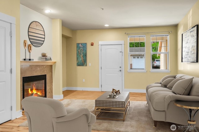 living room with a premium fireplace, light wood-type flooring, recessed lighting, and baseboards