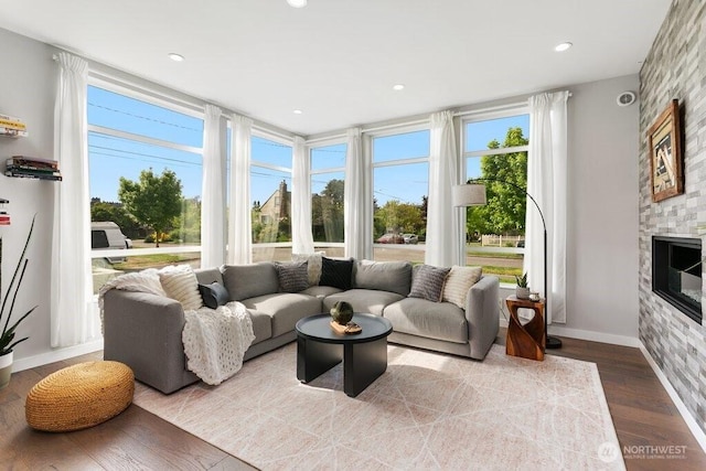 living room with wood finished floors, a fireplace, baseboards, and recessed lighting