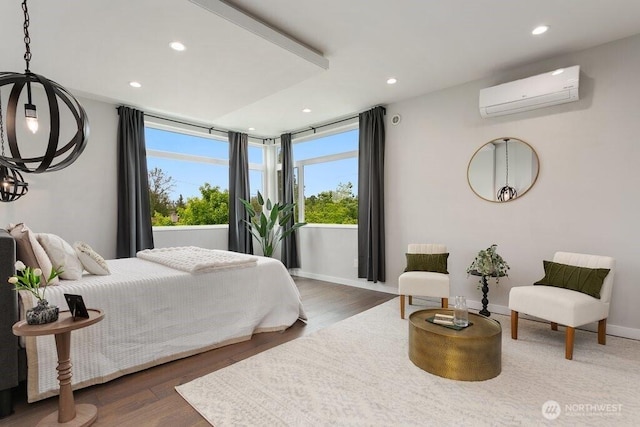 bedroom featuring a wall unit AC, recessed lighting, wood finished floors, baseboards, and a chandelier