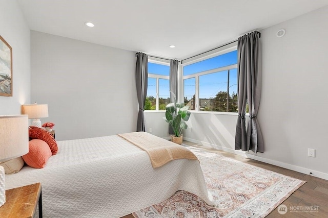 bedroom with wood finished floors, recessed lighting, and baseboards