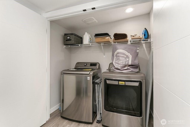 washroom with washer and dryer and wood finished floors