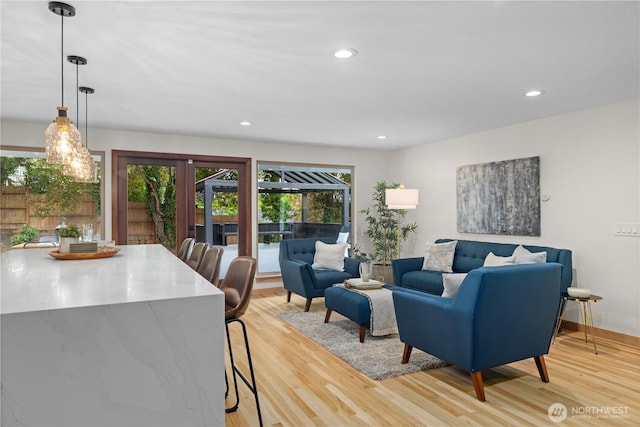 living area with light wood-style flooring, french doors, recessed lighting, and baseboards