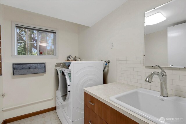 laundry area with a sink, independent washer and dryer, baseboards, and light flooring