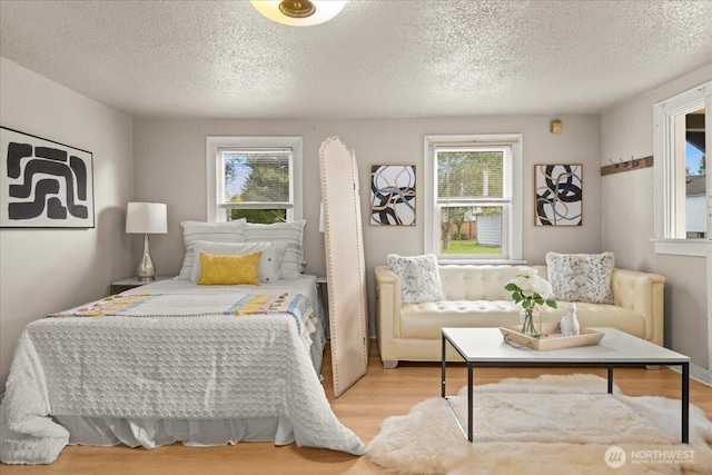 508 N 95th St, Seattle, WA 98103 - bedroom with multiple windows, wood finished floors, and a textured ceiling