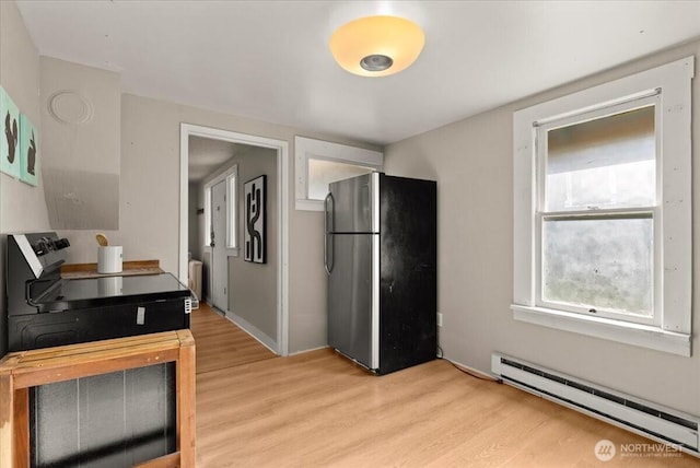 508 N 95th St, Seattle, WA 98103 - kitchen featuring freestanding refrigerator, baseboard heating, radiator, light wood finished floors, and black range with electric stovetop