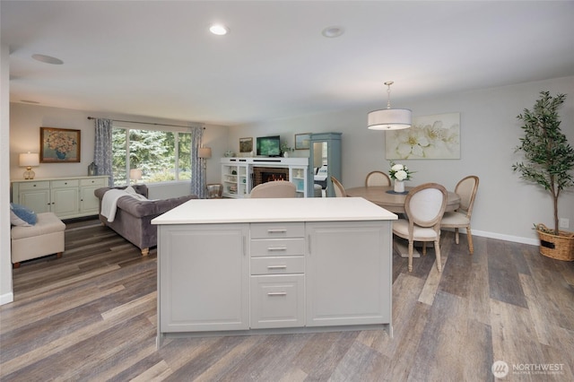 24222 92nd Ave W, Edmonds, WA 98020 - kitchen with open floor plan, dark wood finished floors, a kitchen island, a warm lit fireplace, and light countertops