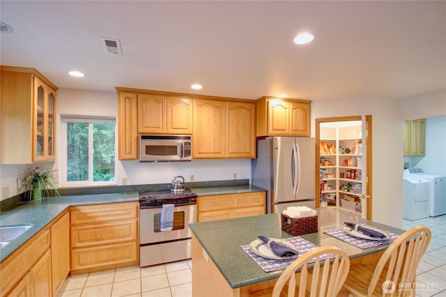 362 N Sunrise Blvd, Camano Island, WA 98282 - kitchen featuring appliances with stainless steel finishes, separate washer and dryer, light tile patterned floors, glass insert cabinets, and recessed lighting