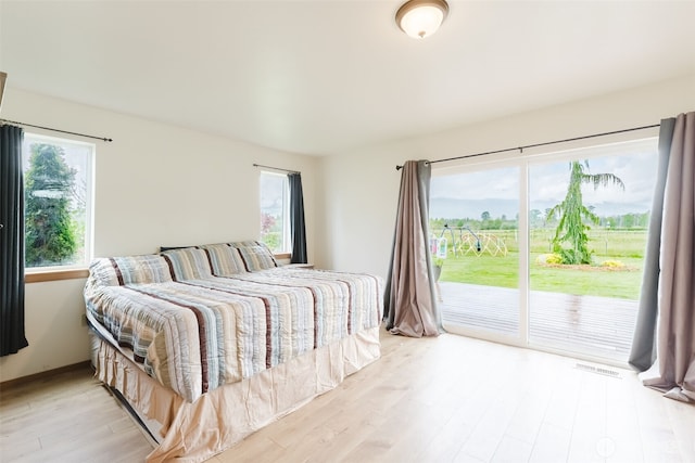 bedroom with access to outside and light wood-type flooring