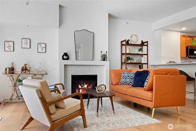 2607 Western Ave Unit 202, Seattle, WA 98121 - living room with light wood-type flooring, a tile fireplace, and recessed lighting
