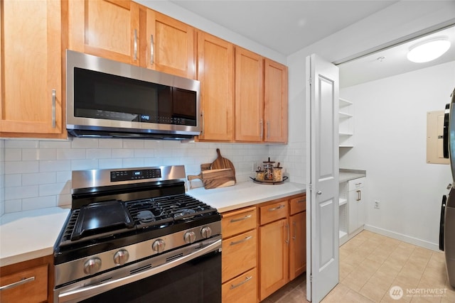 2607 Western Ave Unit 202, Seattle, WA 98121 - kitchen featuring appliances with stainless steel finishes, light countertops, light tile patterned flooring, and decorative backsplash
