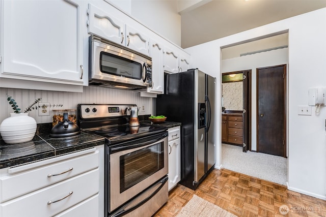 135 N 46th St Unit 402, Seattle, WA 98103 - kitchen with appliances with stainless steel finishes, white cabinetry, and baseboards