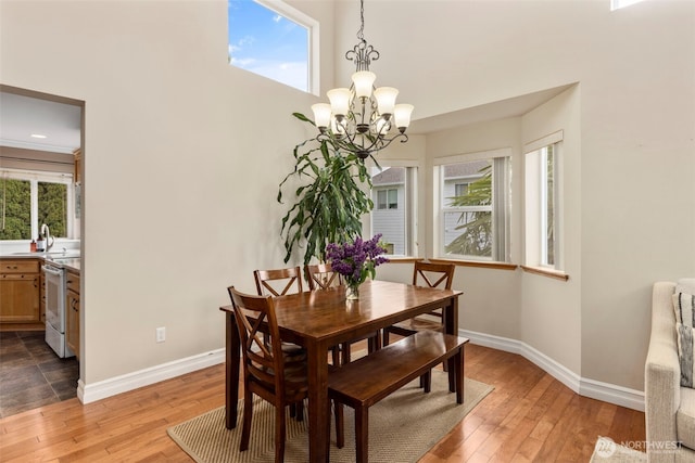 dining room featuring a chandelier, baseboards, and light wood-style flooring